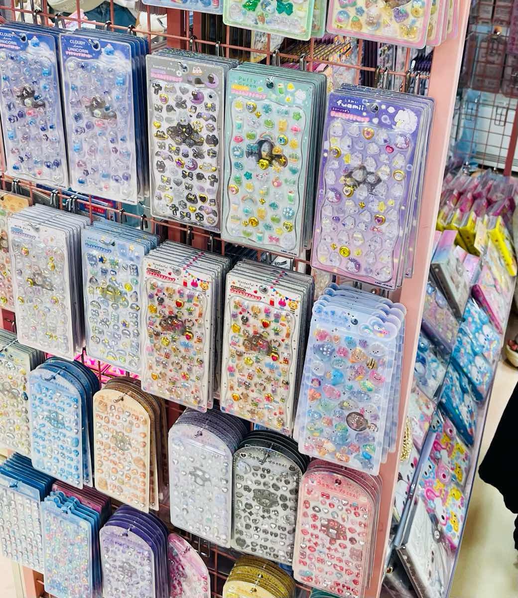 Display of colorful sticker albums in a Japanese stationery shop / 日本の文房具店で並ぶカラフルなシール帳