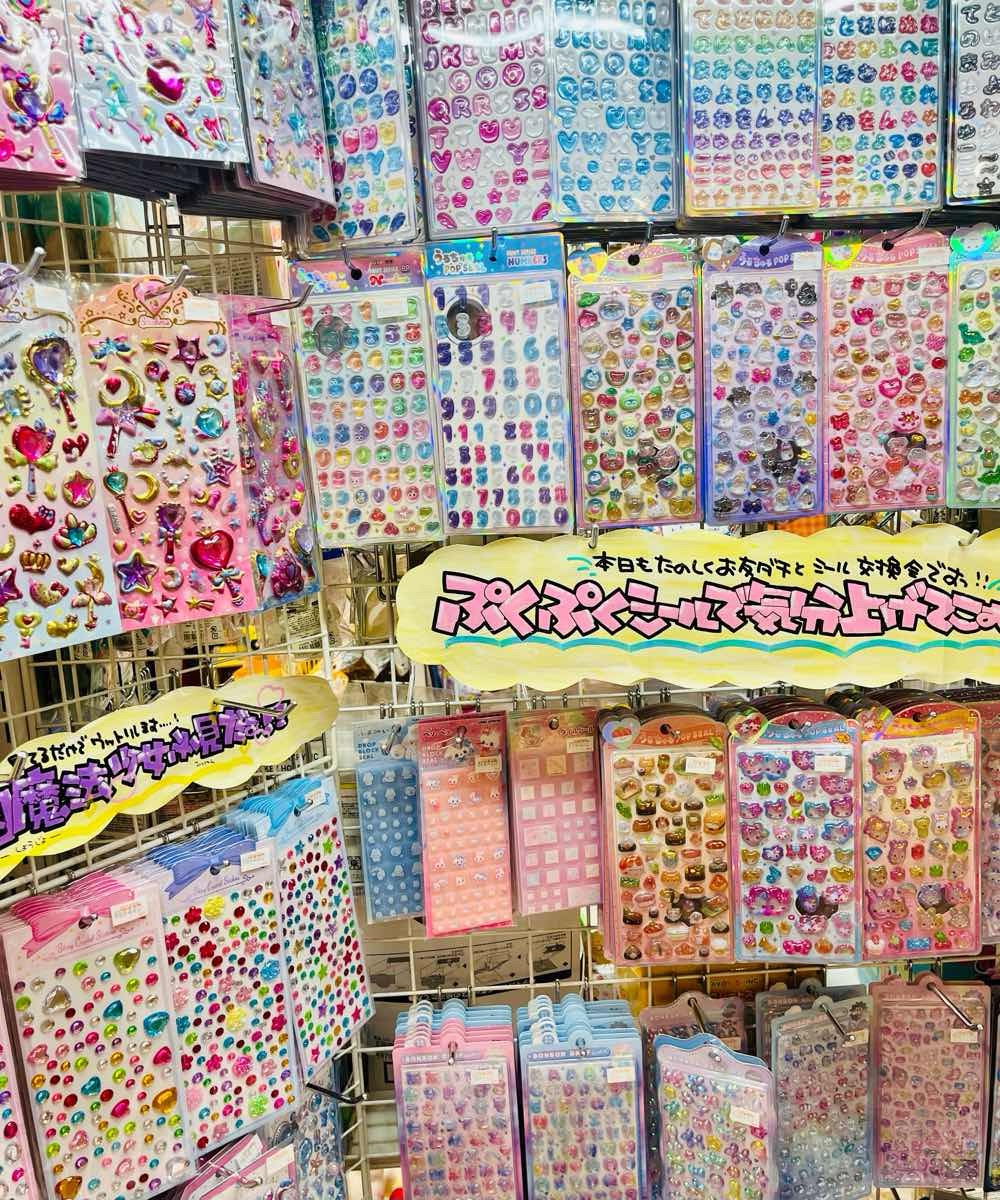 Display of newly released 90s-inspired stickers in a Japanese shop / 日本のショップに並ぶ“90年代風”の新作ステッカー（縦）