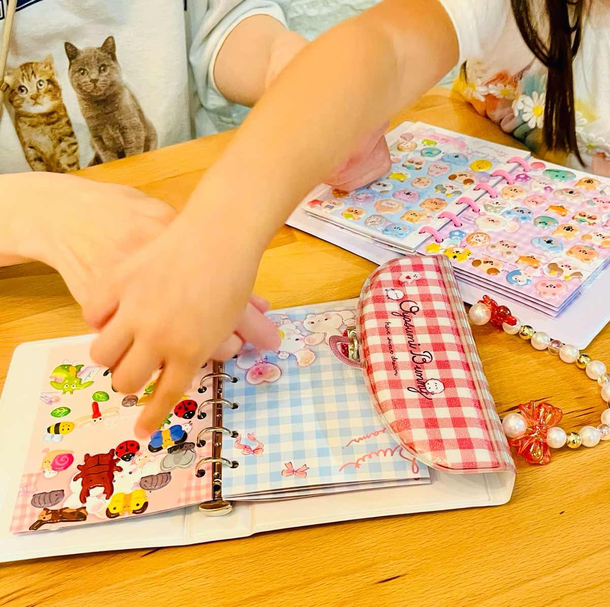 Two hands exchanging kawaii stickers during a sticker trade / シール交換でかわいいシールをやりとりする2人の手